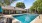 tables and chairs with umbrellas poolside