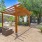 large tree shades chairs near grills